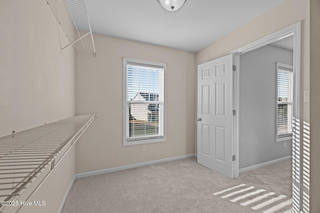 walk in closet featuring light colored carpet