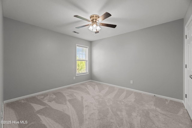 spare room with ceiling fan and carpet