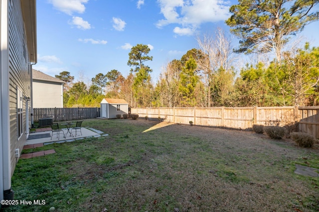 view of yard featuring central AC, a patio, and a storage unit