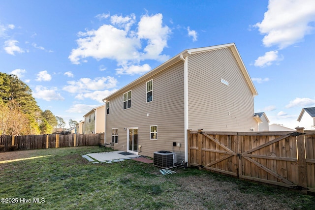 rear view of property with a patio area, a yard, and central AC