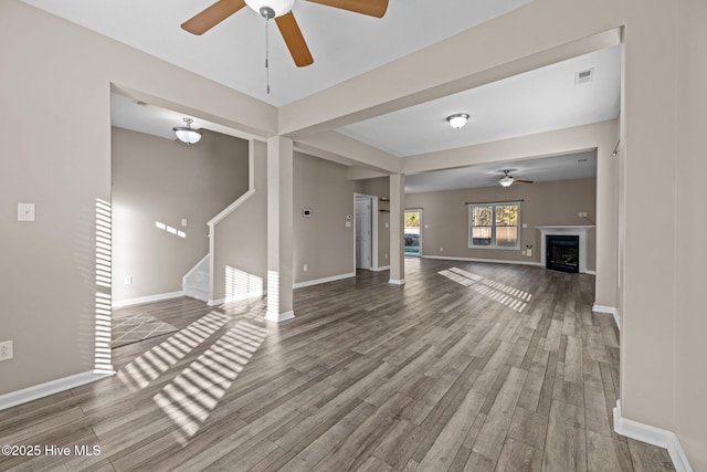 unfurnished living room featuring hardwood / wood-style flooring and ceiling fan