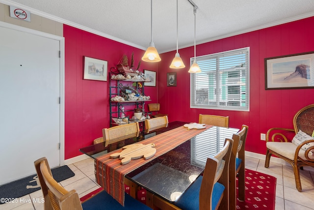 tiled dining area featuring a textured ceiling and crown molding