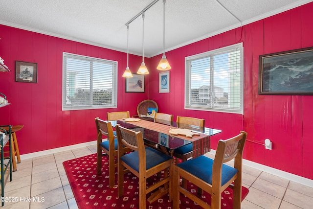 tiled dining area featuring plenty of natural light, crown molding, track lighting, and a textured ceiling