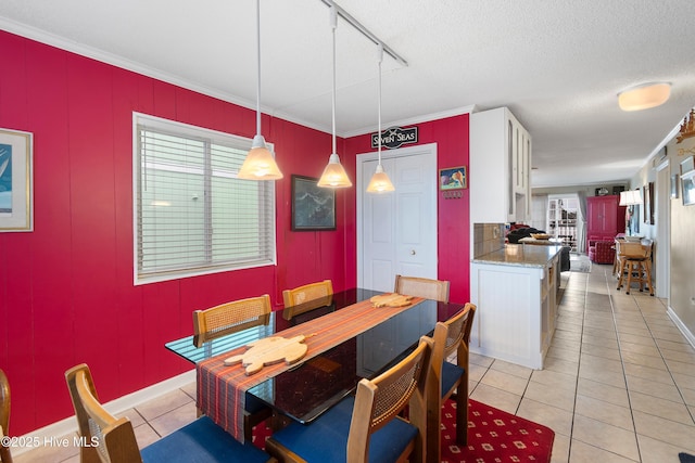 dining space featuring light tile patterned floors, crown molding, and a textured ceiling