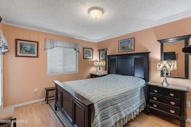 bedroom featuring light wood-type flooring, crown molding, and a textured ceiling