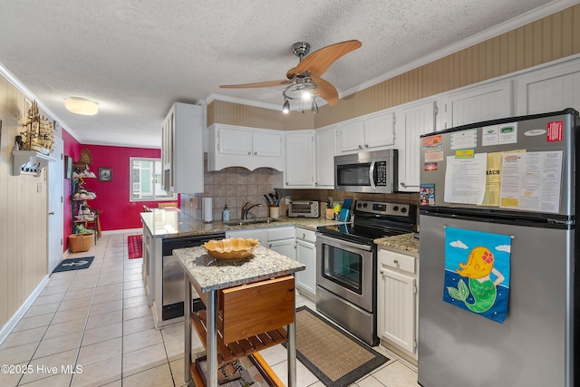 kitchen featuring light stone countertops, appliances with stainless steel finishes, and ornamental molding