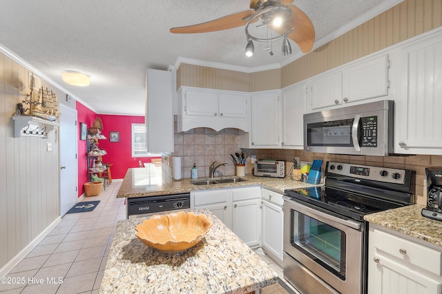 kitchen with a textured ceiling, appliances with stainless steel finishes, white cabinetry, sink, and light tile patterned flooring