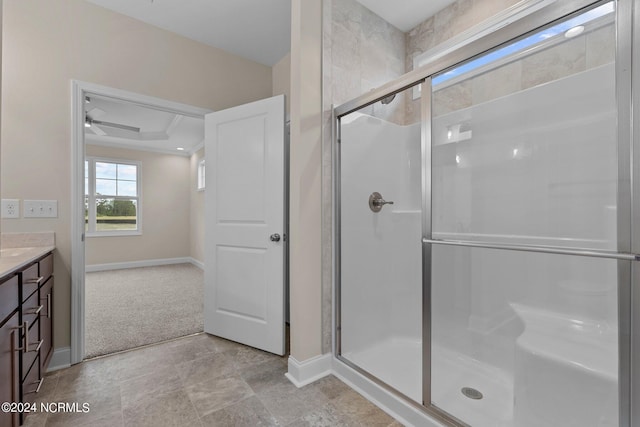 bathroom with a shower with door, a raised ceiling, and vanity