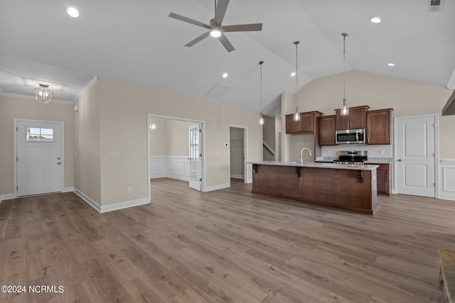 kitchen featuring sink, light hardwood / wood-style flooring, an island with sink, pendant lighting, and stainless steel appliances