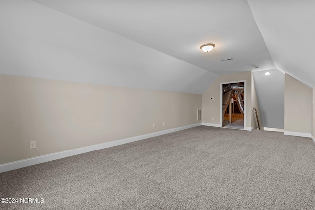 bonus room with vaulted ceiling and carpet floors