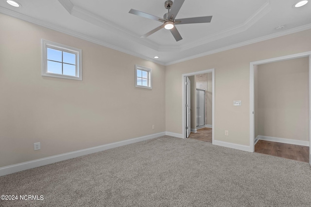 unfurnished bedroom with crown molding, light colored carpet, ceiling fan, and a tray ceiling