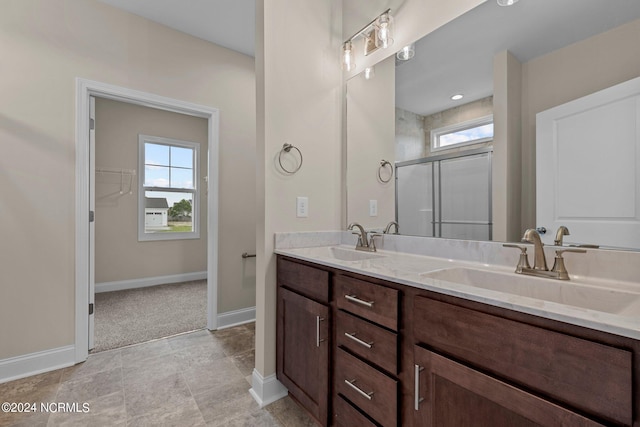 bathroom with a shower with door, vanity, and a wealth of natural light