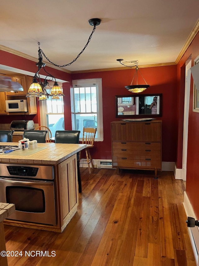 kitchen featuring white microwave, stainless steel oven, dark wood-style flooring, and crown molding