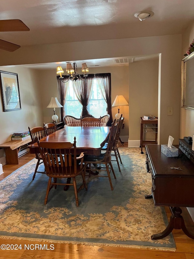 dining area with light wood-style floors and a notable chandelier