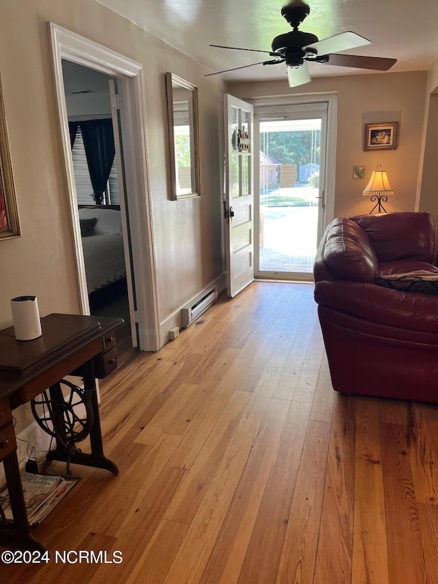 interior space featuring a ceiling fan, light wood-type flooring, and baseboard heating