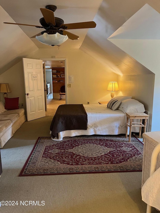 carpeted bedroom with vaulted ceiling and a ceiling fan