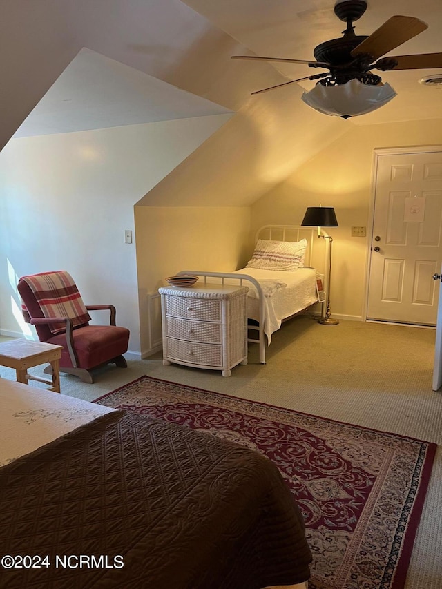 carpeted bedroom featuring vaulted ceiling, baseboards, visible vents, and a ceiling fan