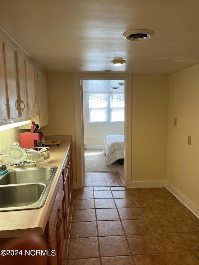 kitchen featuring light countertops, a sink, and baseboards