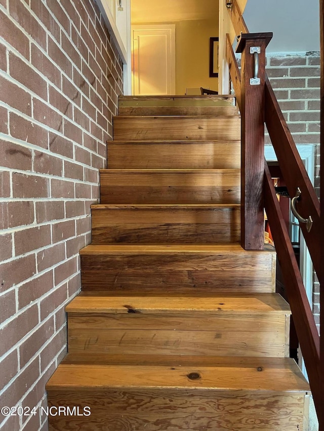 stairs featuring brick wall