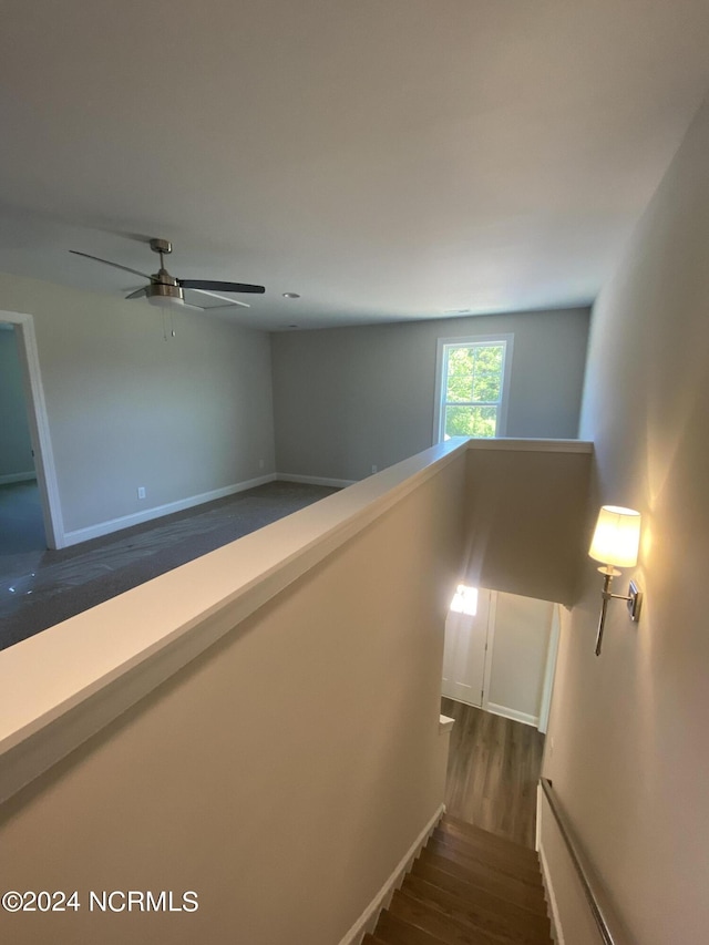 stairway with ceiling fan and hardwood / wood-style floors