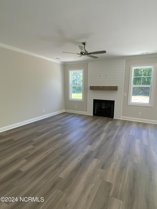 unfurnished living room with ceiling fan, a fireplace, crown molding, and dark hardwood / wood-style floors