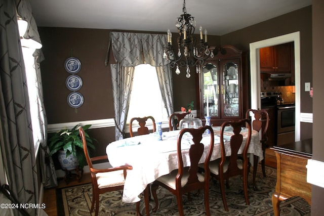 dining room with hardwood / wood-style floors and a notable chandelier