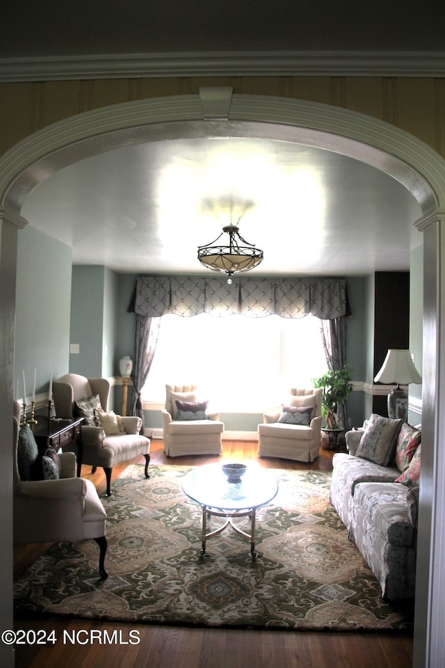 living room featuring a wealth of natural light, decorative columns, and hardwood / wood-style floors