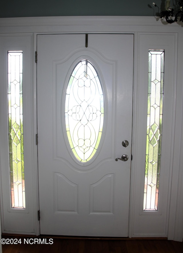 entryway featuring an inviting chandelier and dark wood-type flooring