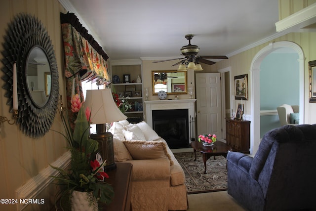 living room featuring carpet floors, ceiling fan, and crown molding