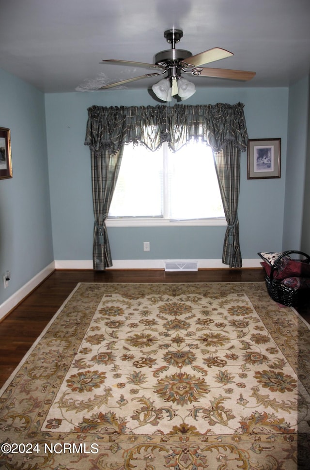 empty room featuring a wealth of natural light, hardwood / wood-style floors, and ceiling fan