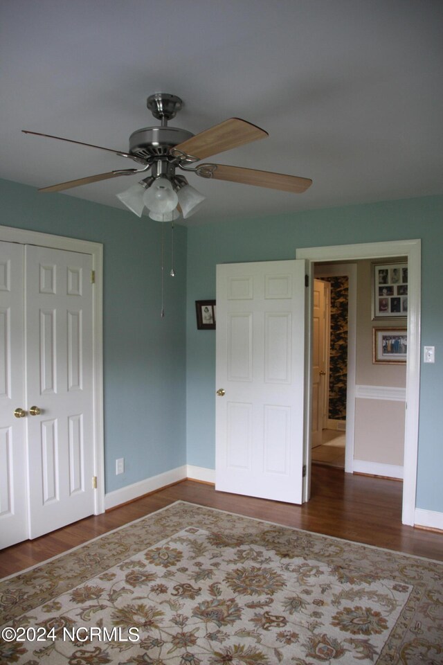 unfurnished bedroom with hardwood / wood-style flooring, a closet, and ceiling fan