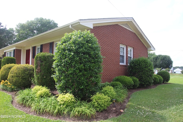 view of side of home with a yard