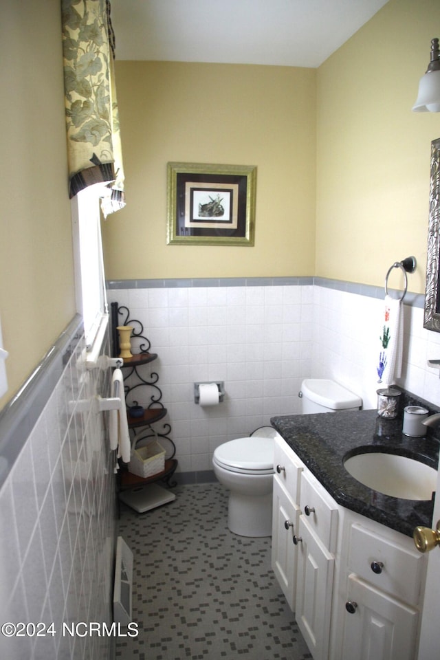 bathroom with tile floors, vanity, tile walls, tasteful backsplash, and toilet