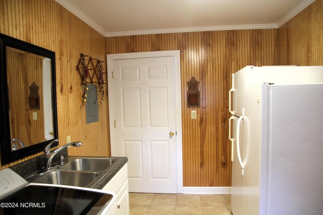 kitchen with white cabinets, light tile flooring, white refrigerator, ornamental molding, and sink