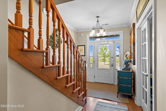 135 Vashti Dr, Morehead City, NC 28557 - entryway with stairway, crown molding, a notable chandelier, and wood finished floors
