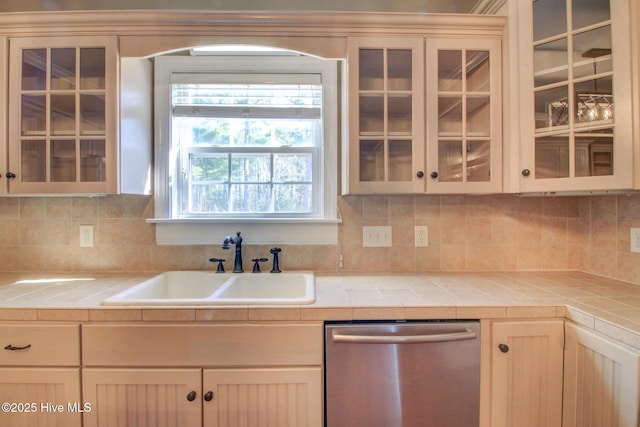 135 Vashti Dr, Morehead City, NC 28557 - kitchen with backsplash, stainless steel dishwasher, a sink, and glass insert cabinets