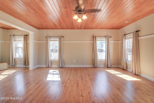 empty room featuring baseboards, wooden ceiling, ceiling fan, crown molding, and light wood-style floors