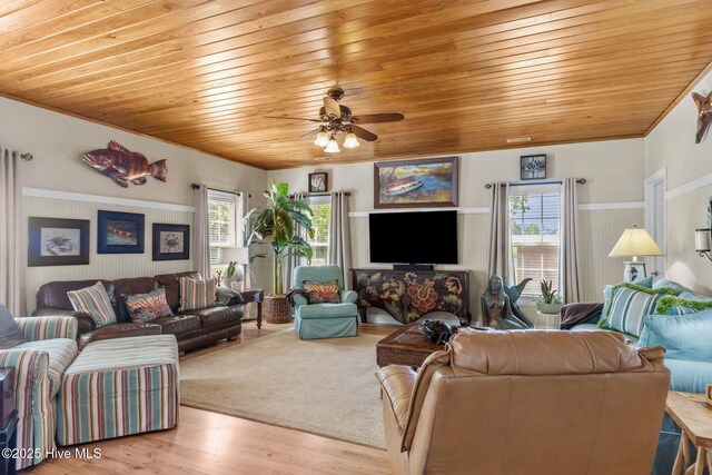 living room featuring ornamental molding, light wood finished floors, wood ceiling, and a ceiling fan