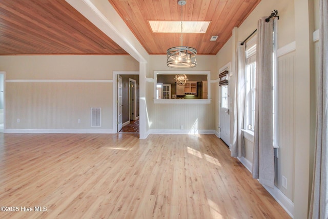 entrance foyer with a skylight, visible vents, wooden ceiling, light wood-style floors, and a notable chandelier