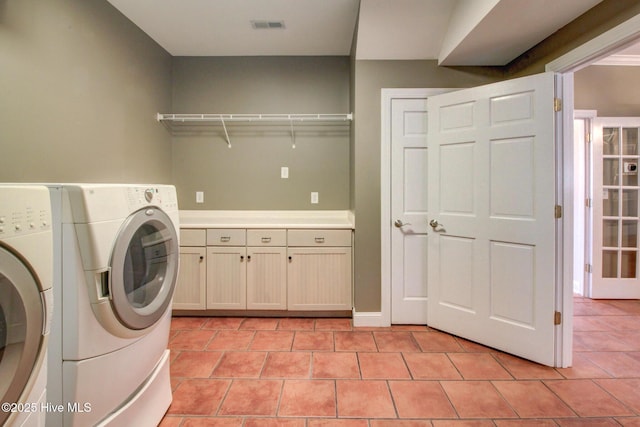 washroom with light tile patterned floors, separate washer and dryer, cabinet space, and visible vents