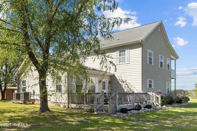 rear view of property with a lawn and a wooden deck