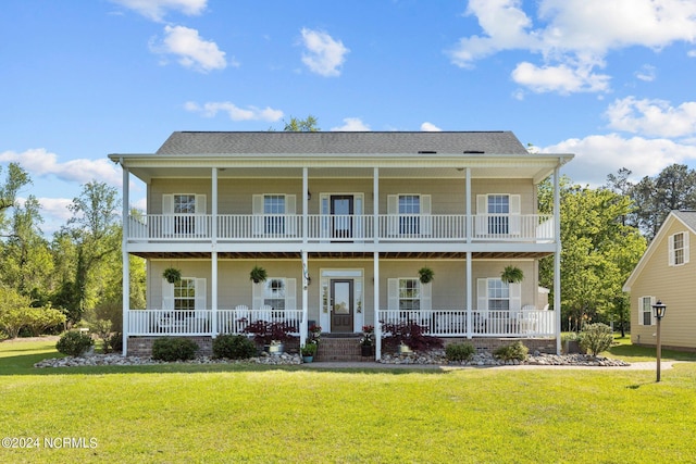 view of front of home featuring a balcony, covered porch, and a front yard