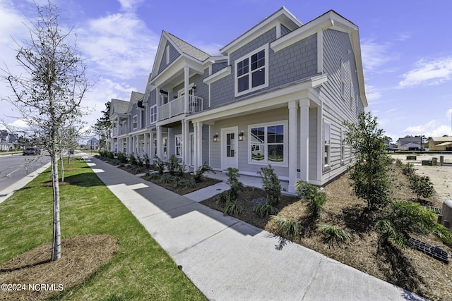 view of front of house with a front yard and a balcony