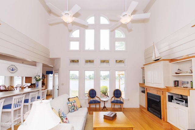 living area with plenty of natural light, a fireplace, and a ceiling fan