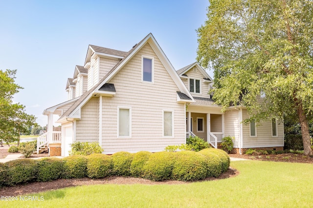 view of front of home featuring a garage, roof with shingles, and a front yard