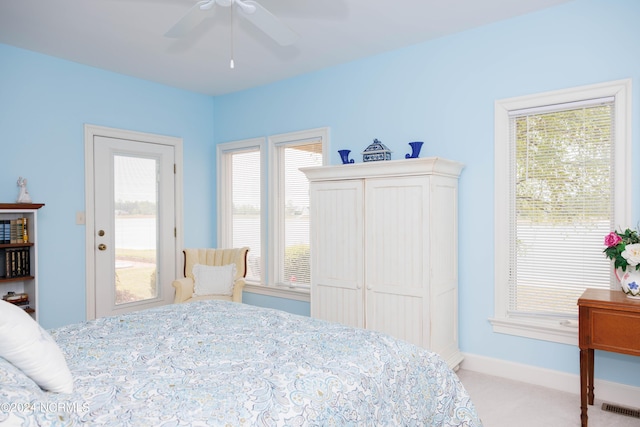 bedroom with light carpet, a ceiling fan, visible vents, and baseboards