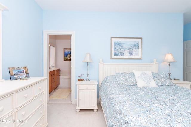 bedroom with connected bathroom and light colored carpet