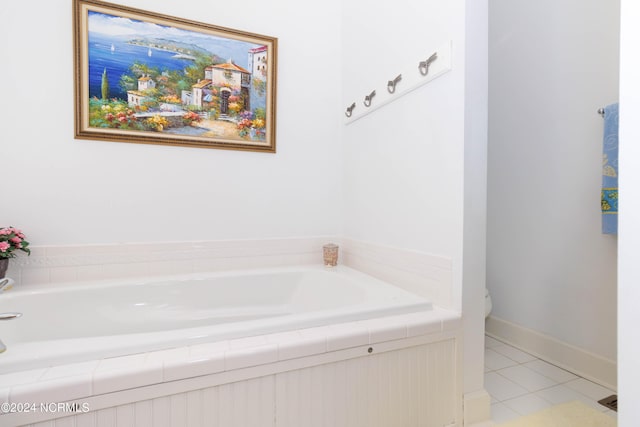 bathroom featuring baseboards, a bath, and tile patterned floors