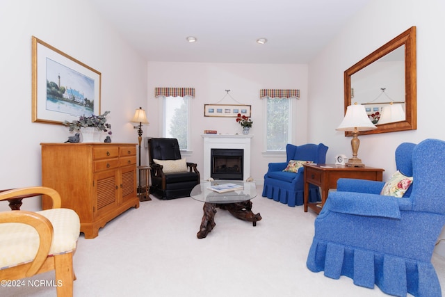 carpeted living room featuring a healthy amount of sunlight, recessed lighting, and a glass covered fireplace