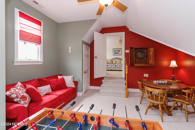 living room featuring lofted ceiling, carpet flooring, visible vents, baseboards, and a ceiling fan